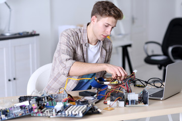 Young man repairing computer hardware in service center