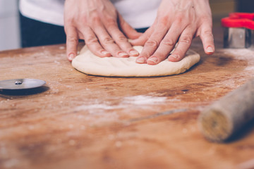 Woman hands kneading dough on the table