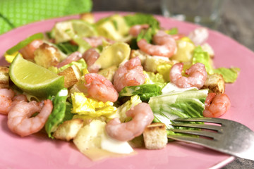 Caesar salad with shrimps and cheese.