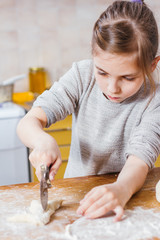 Girl making pasta from dough