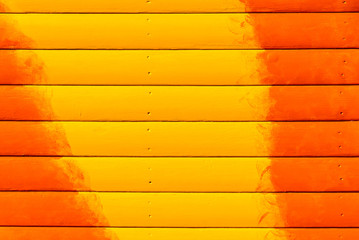 Section of orange and yellow panelling from a beach hut, suitable for backgrounds of beach, seaside and summer holiday themes.