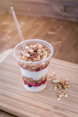 yogurt with granola,honey, almond and fresh berries on wooden board