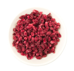 Dried pomegranate seeds in white bowl over white background