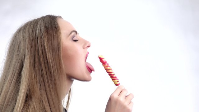 Beautiful girl licking a lollipop