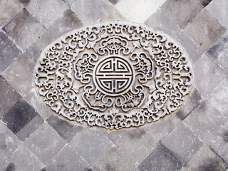 Classical Chinese ornamental design on grey brick wall