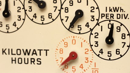 Time lapse close up of the dials of an electricity supply meter with the needles moving quickly. Measuring the consumption of electrical energy.