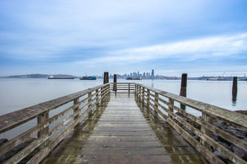 old wood footpath near lake and cityscape of seattle in cloudy s