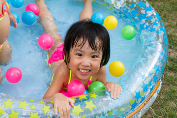 Fototapeta na wymiar Asian Little Chinese Girl Playing in an Inflatable Rubber Swimmi