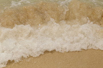Sea wave swash on sand beach.