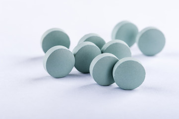 Blue medicine pills on white background. Pharmaceutical medicament.