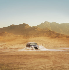 Fototapeta na wymiar Offroad SUV riding in the desert