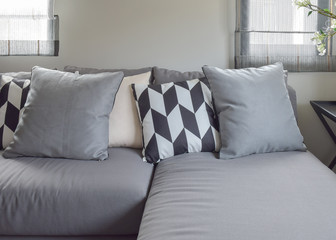 Black and white parallelogram pattern pillows on gray l shape comfy sofa