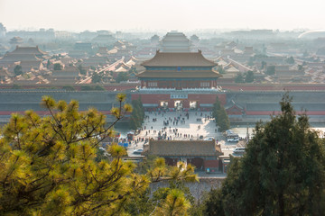 An aerial bird view of the the famous Forbidden City in Beijing, China. The vast area of the architectural complex is covered with evening mist.