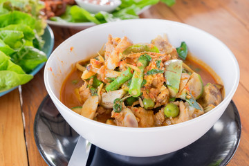 Close up spicy red curry with chicken and herbs