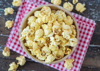 popcorn in brown bowl on dark wooden table.