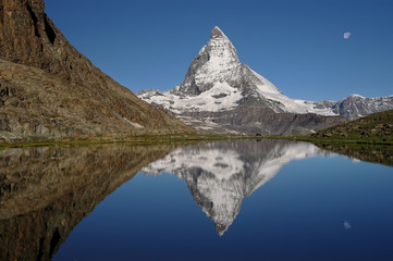 Fototapeta na wymiar Matterhorn view at sunny day with reflection in water