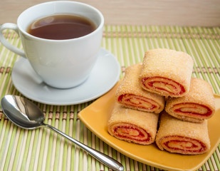 Puff pastry with jam on a plate and cup of tea