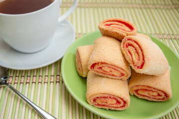 Puff pastry with jam on a plate and cup of tea