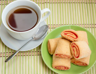 Puff pastry with jam on a plate and cup of tea