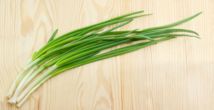 Bunch of a green onion on a wooden surface