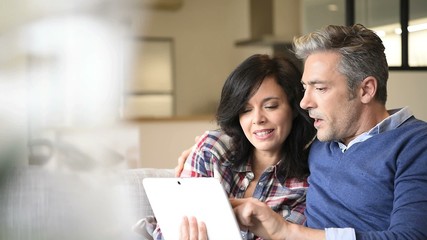 Couple at home websurfing with digital tablet - Powered by Adobe