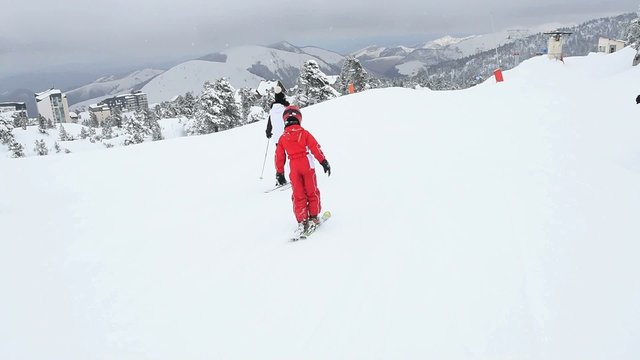 Family of four skiing down slope