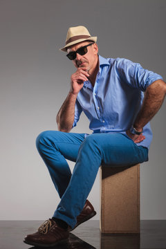 Mature Man Wearing Hat And Sunglasses While Thinking