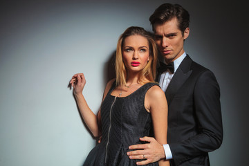 businessman in black embracing woman from behind