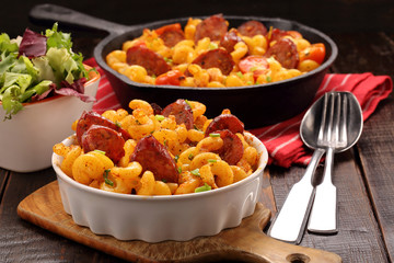 Casserole with chorizo sausage on wooden background