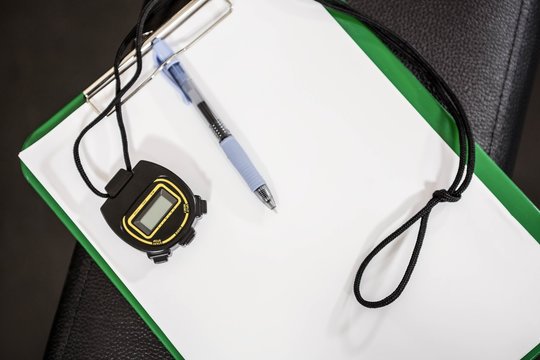 Clipboard and stopwatch on a bench