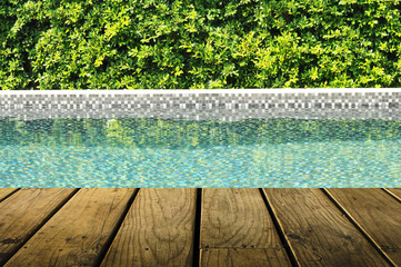 Fototapeta na wymiar Swimming pool with tree fence and grunge wood plank