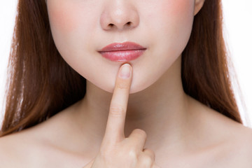 唇を指差す女性