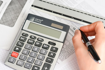 Tax forms with pen, envelope and calculator suggesting annual finance operations 