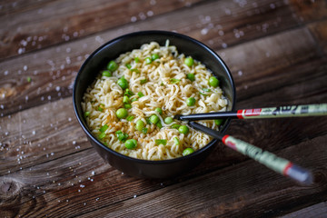 Bowl of noodles with fresh peas and chopped onion.