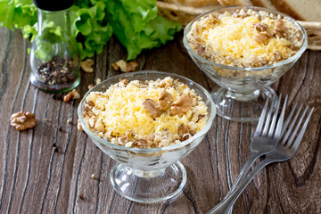 Salad with chicken, walnuts and cheese on a dark wooden table