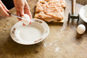 Woman breaks raw egg 