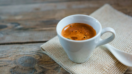 A cup of espresso coffee on the wooden table