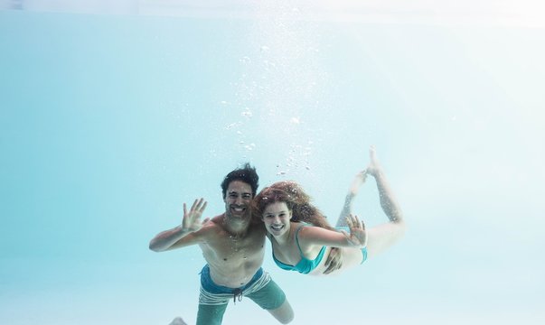 Smiling couple under water - Powered by Adobe