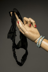 Woman's hand with nail polish gives her black panties