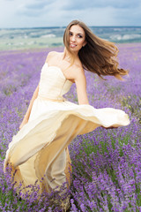 Fototapeta na wymiar Bride girl with flying hair at lavender field