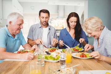 Family sitting at dining table with food