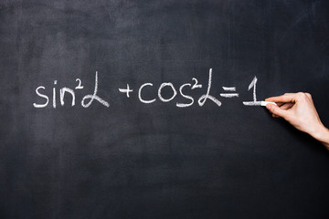 Hand writing trigonometry formula on blackboard - obrazy, fototapety, plakaty