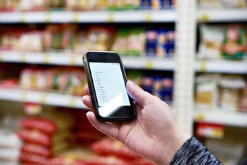 Shopping list on smartphone screen in hand of women customers