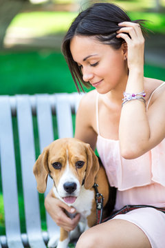 portrait of young beautiful woman with a dog outdoors