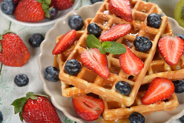 Obraz premium Waffles with berries and caramel sauce