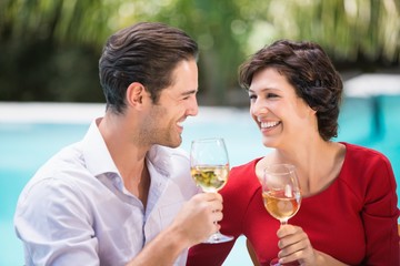 Happy couple holding white wine 