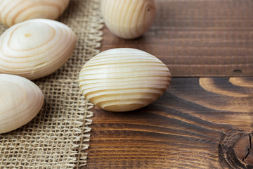 Beautiful wooden Easter eggs lying on the sacking and old brown boards, with free space for your text