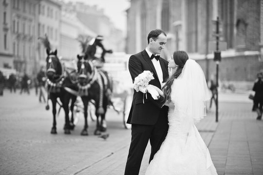 Young elegant and hearty wedding couple in love on streets of Krakow, Poland