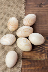 Beautiful wooden Easter eggs lying on the sacking and old brown boards, with free space for your text