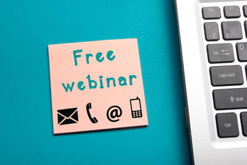 Free webinar. Office table top view - Laptop and reminder with text.